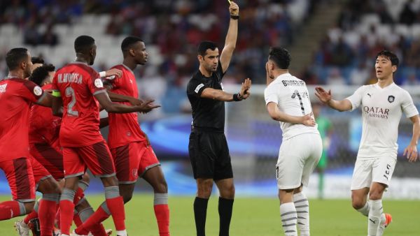 Qatari referee Abdulrahman Al-Jassim (C) presents a yellow card to Sadd's forward Baghdad Bounedjah (2nd-R)