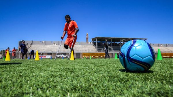 A Palestinian amputee using crutches participates in a football training in Gaza