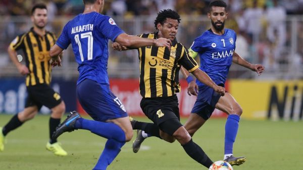 Ittihad's forward Romario Da Silva (C) vies for the ball with Hilal's defender Abdullah al-Hafith (L)