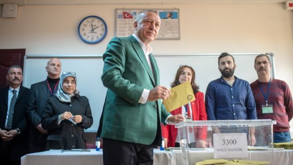 In this file photo taken on March 31, 2019 Turkish President Tayyip Erdogan (C) stands prior to cast his ballot at a polling station during the municipal elections in Istanbul. (BULENT KILIC / AFP)