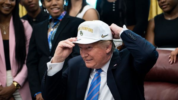 US President Donald Trump puts on a hat given to him by the 2019 NCAA Division I champions from Baylor University's women's basketball team April 29, 2019 at the White House in Washington, DC. (AFP)
