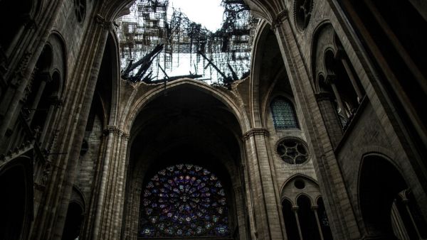 This photo shows one of the rose windows below the damaged roof of Notre-Dame-de Paris Cathedral in Paris on April 16, 2019. (Amaury BLIN / AFP)