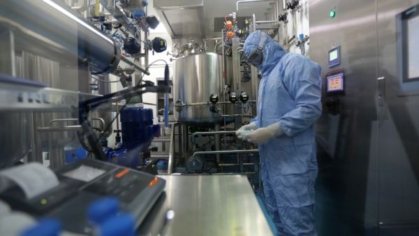 Pharmaceutical factory workers dressed in chemical safety suits work in the bioreactor room at the Actoverco plant in Karaj, about 40 kilometres (nearly 25 miles) west of Iran's capital Tehran, on February 18, 2020. AFP
