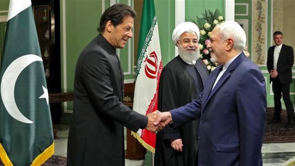 Iranian Foreign Minister Mohammad Javad Zarif (R) welcoming Pakistani Prime Minister Imran Khan as President Hassan Rouhani looks on, in Tehran. (AFP)