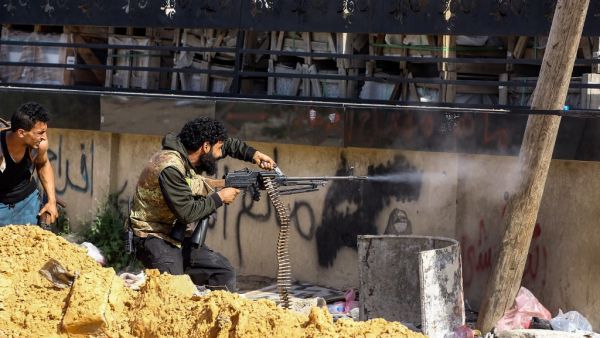 A Libyan fighter loyal to the Government of National Accord (GNA) fires a machine gun during clashes with forces loyal to strongman Khalifa Haftar south of the capital Tripoli's suburb of Ain Zara, on April 10, 2019. (Mahmud TURKIA / AFP)