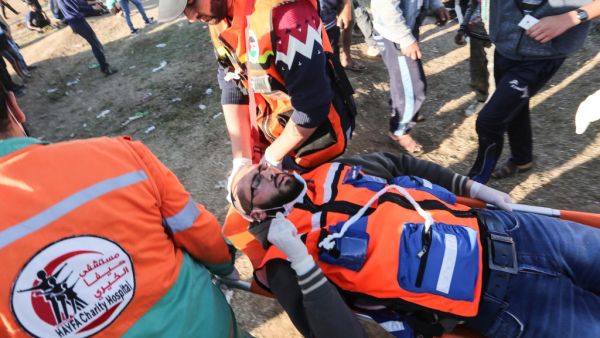 Palestinian paramedics carry a colleague during clashes with Israeli forces following a demonstration by the border fence with Israel, east of Gaza City, on May 3, 3019. (MAHMUD HAMS / AFP)