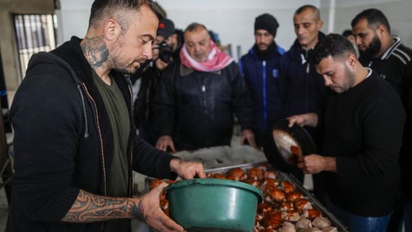 Gabriele Rubini (L), known as Chef Rubio, cooks with Palestinian prisoners at a Hamas-run civilian prison in Gaza City on January 21, 2020, where he is teaching the inmates how to cook Italian food and they teach him Palestinian recipes. MAHMUD HAMS / AFP