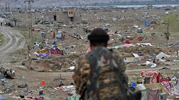 An SDF fighter surveys the bombed-out field below in the remote village of Baghouz close to the Euphrates River in eastern Syria. (AFP/ File PHoto)