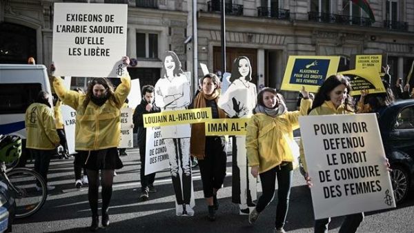 Women's rights activists hold signs as they take part in a demonstration organized by Amnesty International outside the Saudi embassy in Paris, France, on March 8, 2019. (AFP)