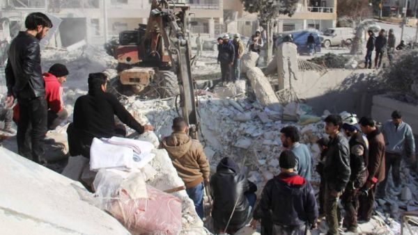 Syrian men and civil defense volunteers search for survivors amid the rubble of a building following airstrike on the northwestern city of Idlib. (AFP)
