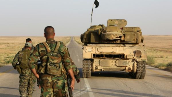 Syrian soldier walk behind a military vehicle (AFP/File Photo)