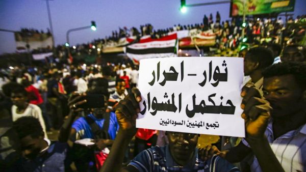 A Sudanese protester holds up a sign reading in Arabic "revolutionaries, free, will continue the course", during a late demonstration demanding a civilian body to lead the transition to democracy. (ASHRAF SHAZLY / AFP)