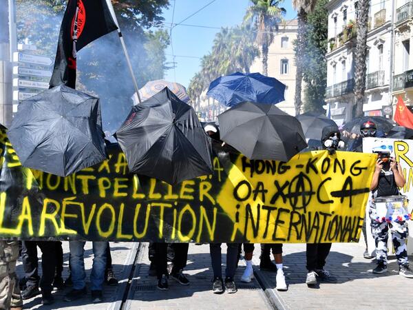 Protestors dressed in black holds umbrellas and a banner reading "Montpellier, Hong Kong, the international revolution" during an anti-government demonstration called by the "Yellow Vests" (Gilets Jaunes) movement on September 7, 2019 in Montpellier, southern France. Pascal GUYOT / AFP