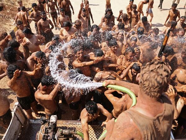 Syrian Turkish-backed fighters from al-Mutasim Brigade shower after finishing their training at a camp near the town of Marea in Syria's northern Aleppo district, on September 12, 2019. Nazeer Al-khatib / AFP