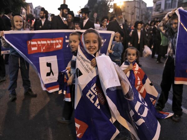 Children play with electoral banners as thousands of Ultra Orthodox Jews attend an election campaign rally of the Yahadut Hathora (United Torah Judaism) at the centre of Jerusalem on September 15 2019, two days ahead of the Israeli general elections. MENAHEM KAHANA / AFP