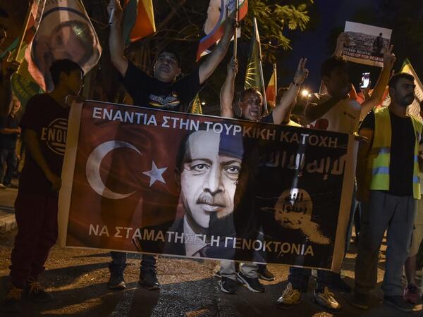 Kurds living in Athens hold flags and banners reading 'Against the Turkish occupation' as they protest near the Turkish embassy in Athens, on October 9, 2019. Louisa GOULIAMAKI / AFP