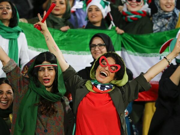 Iranian women cheer during the World Cup Qatar 2022 Group C qualification football match between Iran and Cambodia at the Azadi stadium in the capital Tehran on October 10, 2019. ATTA KENARE / AFP
