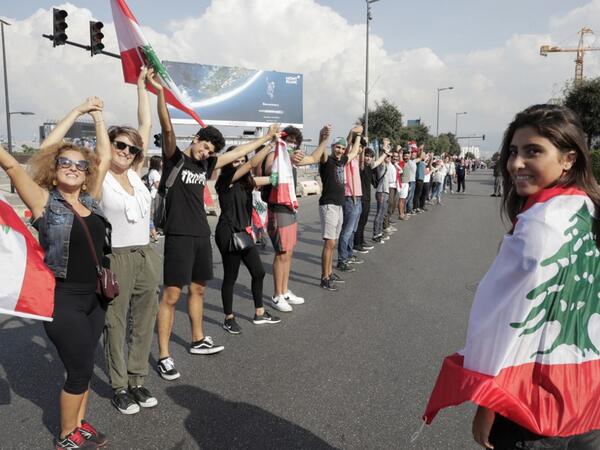 Lebanese protesters hold hands to form a human chain along the coast from north to south as a symbol of unity, during ongoing anti-government demonstrations in Lebanon's capital Beirut on October 27, 2019. ANWAR AMRO / AFP