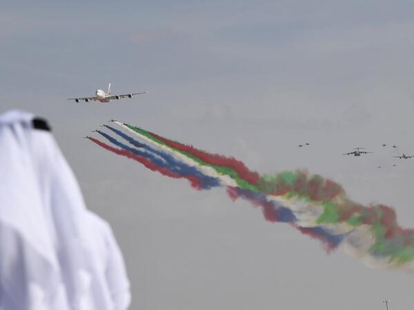 An emirati man watches the United Arab Emirates' air force Aerobatic Team, Al-Fursan, performing along with an Emirates Airline's Airbus A380 at the Dubai Airshow November 17, 2019. KARIM SAHIB / AFP