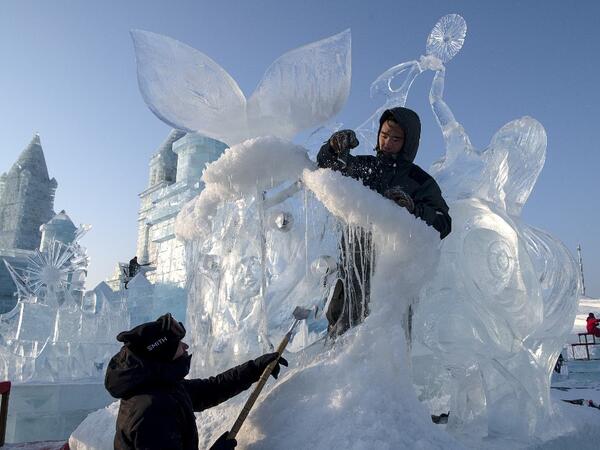 Ice sculptors give finishing touches on an ice sculpture ahead of the opening of the Harbin International Ice and Snow Festival in Harbin, in China's northeast Heilongjiang province on January 3, 2020. NOEL CELIS / AFP