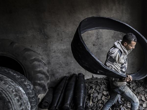 A labourer carries a ripped-out tyre liner at a rubber recycling workshop in the village of Mit al-Harun in Egypt's central Nile delta Gharbia Governorate, about 70 kilometres (43 miles) north of the capital, on January 14, 2020. Khaled DESOUKI / AFP