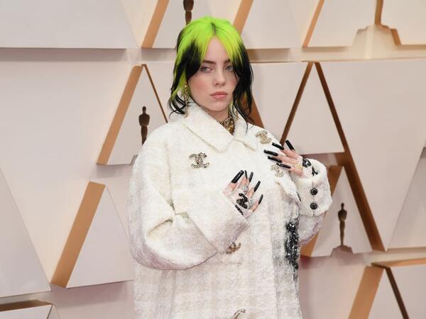 Billie Eilish in a white-on-white houndstooth set, with a jacket featuring the Chanel's interlocking "C" logo