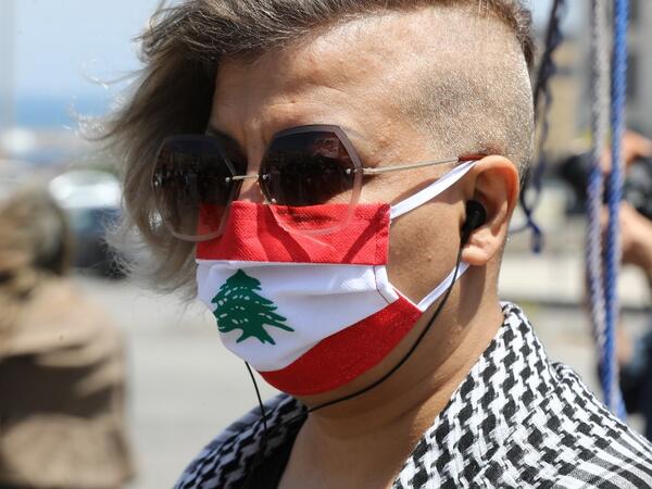 A Lebanese anti-government protester wearing a protective mask designed as a national flag amid the COVID-19 pandemic, takes part in a demonstration in downtown Beirut, on May 1, 2020, marking International Workers' Day (Labour Day). ANWAR AMRO / AFP