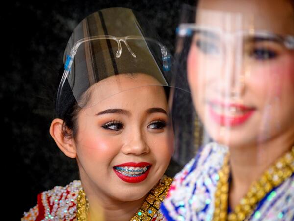 Traditional Thai dancers wearing protective face shields relax after a performance at the Erawan Shrine, which was reopened after the Thai government relaxed measures to combat the spread of the COVID-19 novel coronavirus, in Bangkok on May 4, 2020. Thailand began easing restrictions related to the COVID-19 novel coronavirus on May 3 by allowing various businesses to reopen, but warned that the stricter measures would be re-imposed should cases increase again. Mladen ANTONOV / AFP