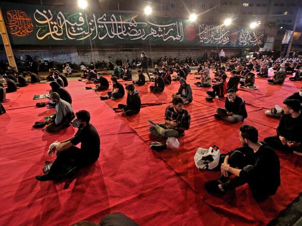 Iranians wearing face masks against the Covid-19 coronavirus attend Laylat al-Qadr prayers, one of the holiest nights during the Muslim fasting month of Ramadan, outside a mosque in the Tehran, on May 13, 2020. ATTA KENARE / AFP