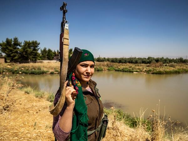 A Kurdish female volunteer, from the newly formed Community Protection Forces, guards a wheat field, against threats by jihadists to burn the crops, during harvest season on June 13, 2020, in the countryside east of Qamishli in Syria's northeastern Hasakah province. Delil SOULEIMAN / AFP