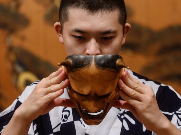 This photo taken on July 29, 2020 shows performer Kennosuke Nakamori putting on the "hannya" mask as he takes part in a rehearsal at the Kamakura Noh Theatre in the town of Kamakura in Kanagawa Prefecture, about one hour southwest of Tokyo. Philip FONG / AFP