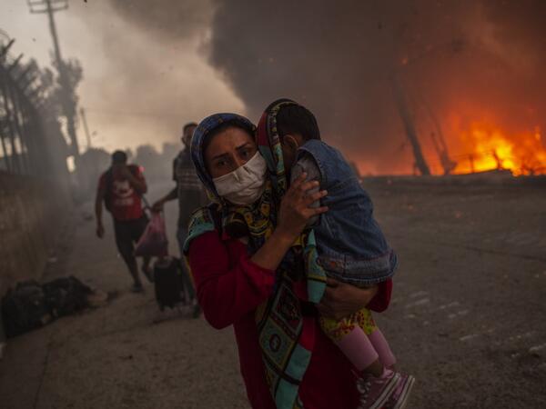A large fire broke out at Moria, Europe's largest refugee camp on Lesbos in Greece, forcing thousands including many families with children out into the streets with nowhere to sleep.   A second fire aggravated the crisis on the island of Lesbos, where authorities have declared a state of emergency.  The first blaze, which began hours after 35 people tested positive for coronavirus at the Moria camp, sent thousands fleeing for safety into surrounding olive groves -- but nobody was seriously hurt.  While Eur