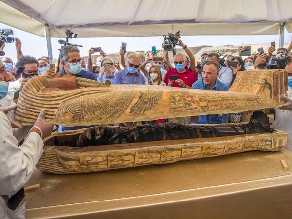 A picture taken on October 3, 2020 shows Egyptian Minister of Tourism and Antiquities Khaled Al-Anani (L), and Mustafa Waziri (R), Secretary General of the Supreme Council of Antiquities, open a sarcophagus excavated by the Egyptian archaeological mission working at the Saqqara necropolis, 30 kms south of the capital Cairo, which resulted in the discovery of a deep burial well with more than 59 human coffins closed for more than 2,500 years. They were unearthed south of Cairo in the sprawling burial ground 