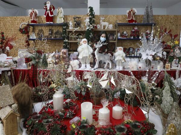 A Palestinian shop-owner arranges Christmas decorations at her shop in the West Bank city of Bethlehem on December 21, 2020. HAZEM BADER / AFP