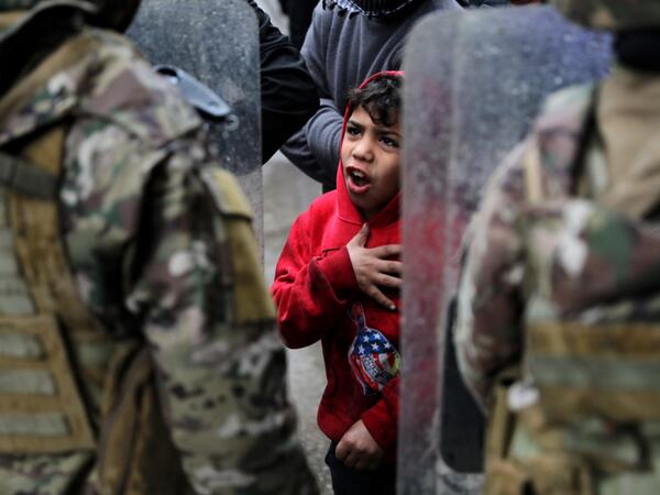 A boy gestures as Lebanese anti-government protesters confront security forces while going around the homes of deputies and government officials in the northern port city of Tripoli to protest the economic situation and their role in leading the country to crisis, on January 28, 2021. Tripoli was already one of Lebanon's poorest areas before the coronavirus pandemic piled new misery onto a chronic economic crisis. Many of its residents have been left without an income since Lebanon imposed a full lockdown e