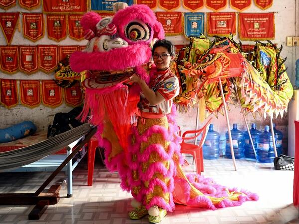 This photograph taken on January 20, 2021 shows Le Yen Quyen posing with her lion dance mask before a practice session at the Tu Anh Duong lion and dragon dance school in Can Tho city in southern Vietnam's Mekong Delta. Manan VATSYAYANA / AFP