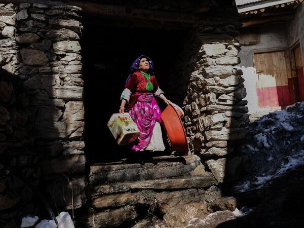 In this photograph taken on February 15, 2021, a Kurdish woman carries plastic boxes in the streets of the village of Guneyyamac in eastern Turkey, as part of an expedition organised by the Bahcesaray public hospital vaccination team, to vaccinate residents of 65 years old or above with Sinovac's CoronaVac Covid-19 vaccine. Turkey's population of more than 83 million is spread out across Europe and Asia and covers some seemingly impregnable terrain. The vaccination effort with China's CoronaVac jab kicked o