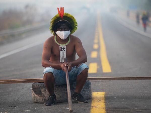  In this file photo taken on August 18, 2020 a member of the Kayapo tribe sits after they blocked highway BR163 during a protest on the outskirts of Novo Progresso in Para State, Brazil, amid the COVID-19 novel coronavirus pandemic. 