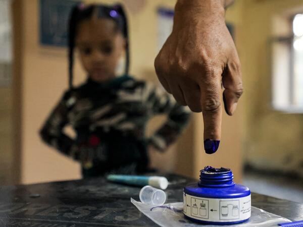 A man dips his finger in ink after voting at a polling station in Iraq's capital Baghdad during the early parliamentary elections on October 10, 2021. (Photo by AHMAD AL-RUBAYE / AFP)