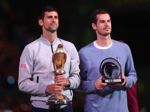 Serbia's Novak Djokovic (L) poses with the winner's trophy after beating Britain's Andy Murray during their final tennis match at the ATP Qatar Open in Doha on January 7, 2017.KARIM JAAFAR / AFP