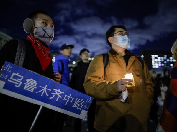 A man holds a candle as people gather at Columbia University 