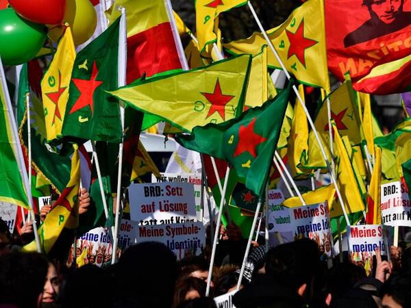 Protesters hold flags during a demonstration of Kurdish groups to protest against Turkey's offensive against Kurds in Syria's Afrin region, on Mar. 3, 2018 in Berlin.
(John MACDOUGALL / AFP)
