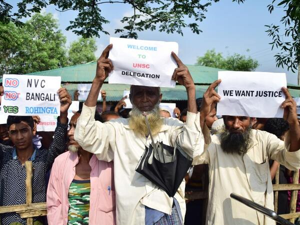 Rohingya refugees hold welcoming placards for members of United Nations Security Council team during their visit to Kutupalong refugee camp in Bangladesh's Ukhia's district on 29 April 2018. Sam Jahan/AFP