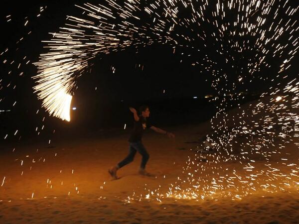 A Palestinian protester from a group calling themselves the "night confusion units" waves a sparkler near the Gaza-Israel border east of Rafah in the southern Gaza Strip, on September 26, 2018. 
SAID KHATIB / AFP