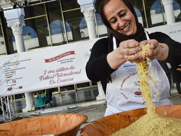 A woman prepares couscous during the 2nd edition of the International Couscous Festival at the Moufdi Zakaria Palace of Culture in the Algerian capital 
RYAD KRAMDI / AFP