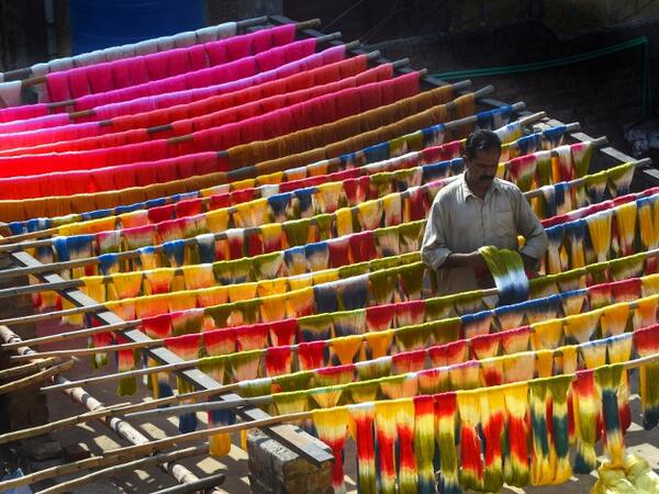 A Pakistani worker dries fabric threads after dyeing them at a factory in Lahore on February 11, 2019. 
ARIF ALI / AFP