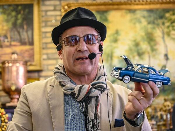 Auctioneer Ali Tuna shows items to the audience at an auction house in Istanbul's Balat district. 
OZAN KOSE / AFP