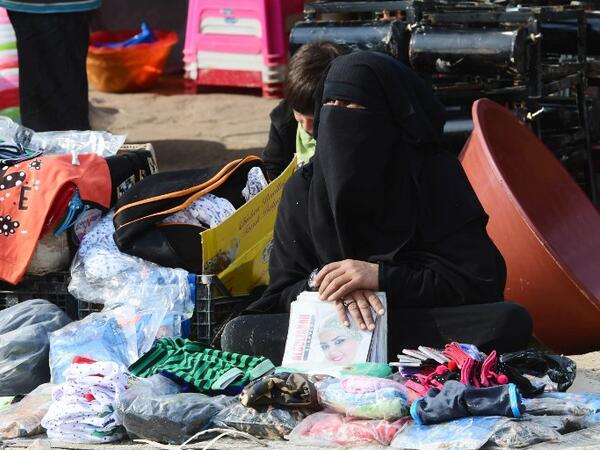 A displaced woman sells second hand items in the souk or market of Al-Hol camp for displaced people in northeastern Syria, which currently brims with more than 70,000 people, even though it was only designed to accommodate a seventh of that number. 
GIUSEPPE CACACE / AFP