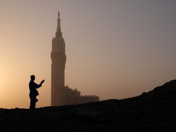 Silhouette of muslim man praying with Makkah Royal Clock Tower in the background (Shutterstock/File Photo)