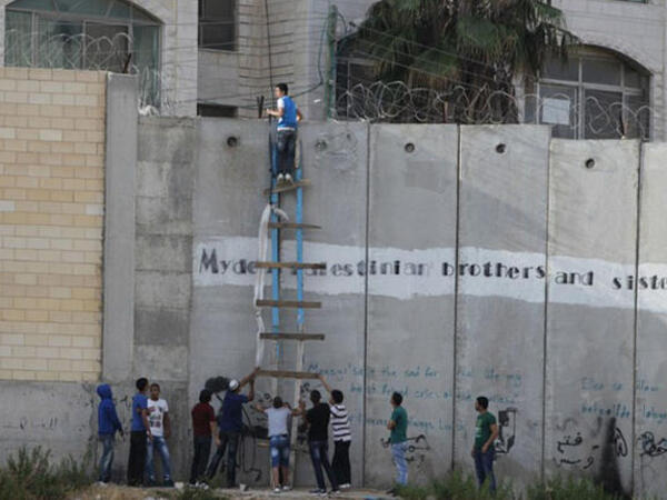 Al-Ram A Palestinian boy looks over the Apartheid Wall 